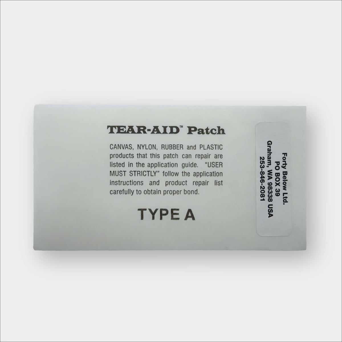 Grey Forty Below Repair Patch Shown with text on it describing instructions and a Forty Below Label Sticker