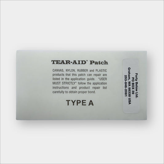 Grey Forty Below Repair Patch Shown with text on it describing instructions and a Forty Below Label Sticker