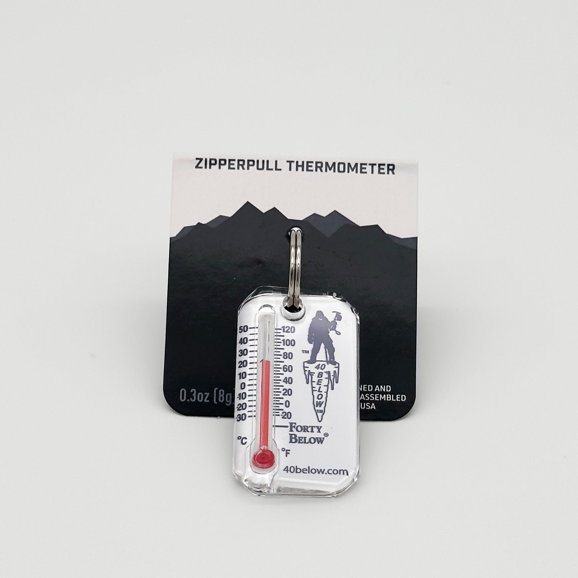 Forty Below Thermometer white with blue text and red thermometer gauge  with part of the packaging behind it